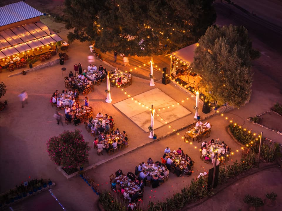 An evening event under festoon lights at a regional estate, seen from above