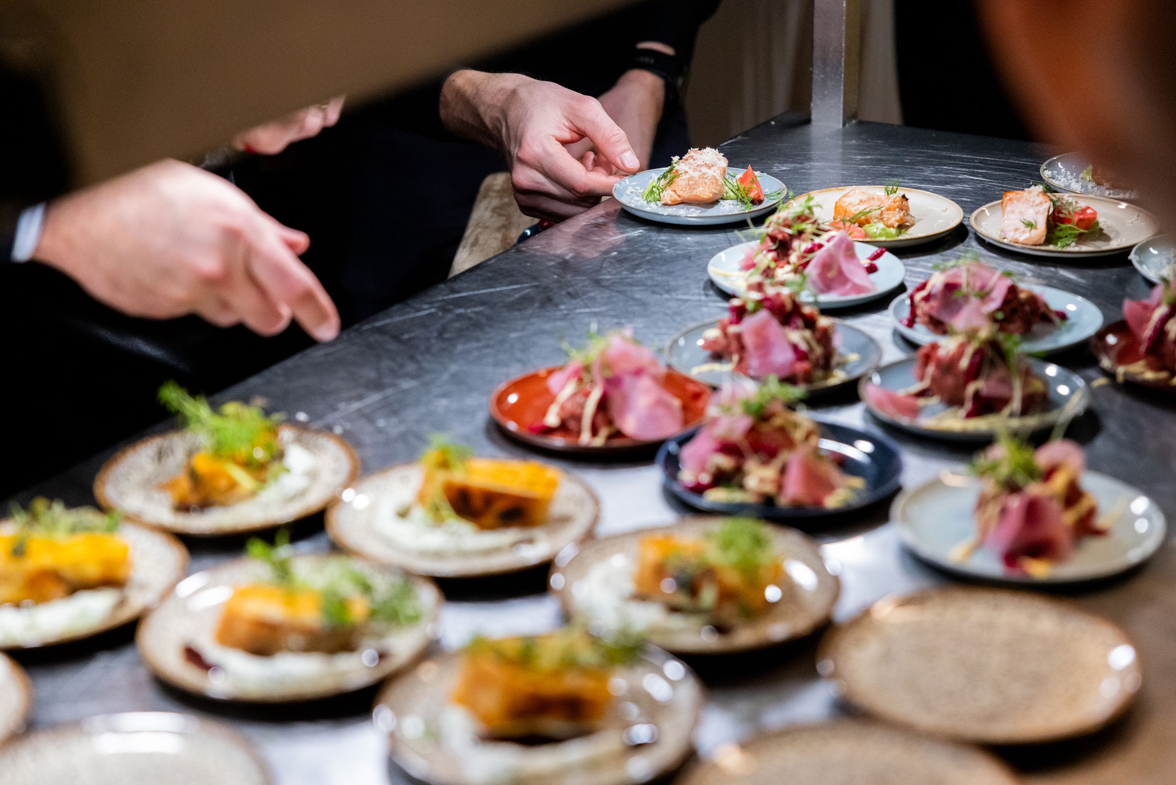 Chefs plating a run of function dishes at the pass