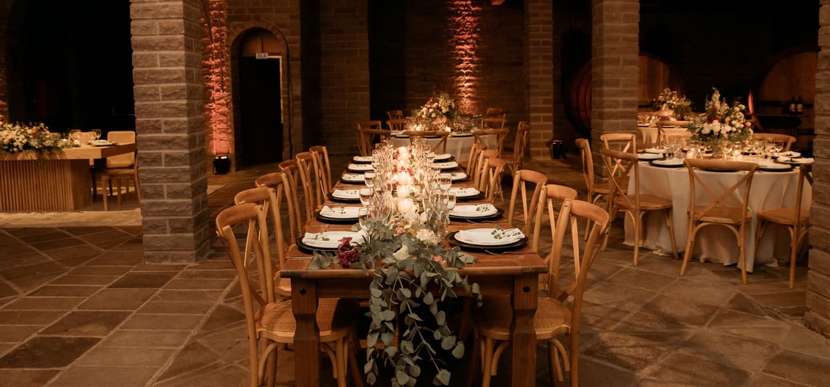 A long table set for an evening event in an estate cellar