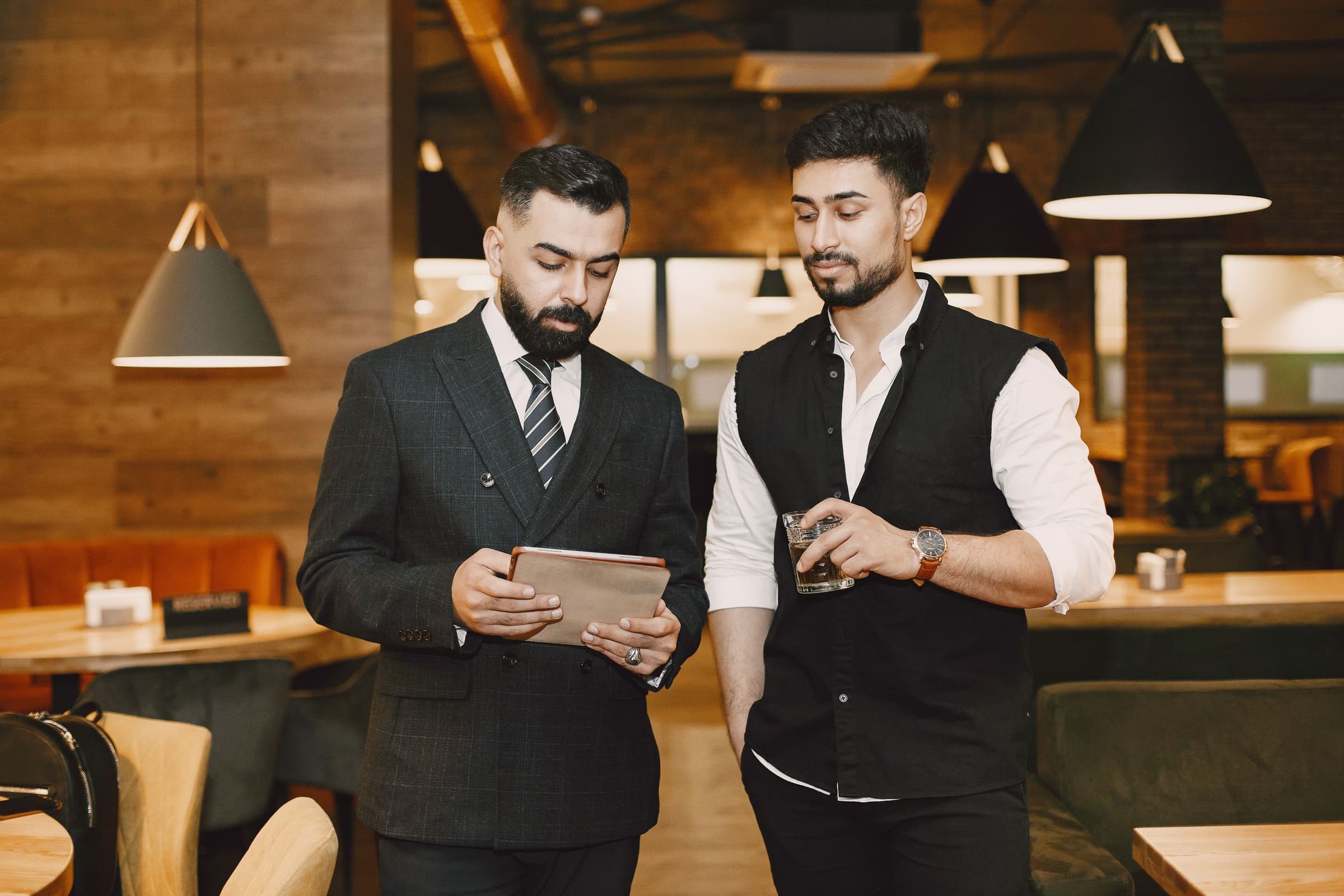 Two managers going over figures on a tablet on the floor of a large venue