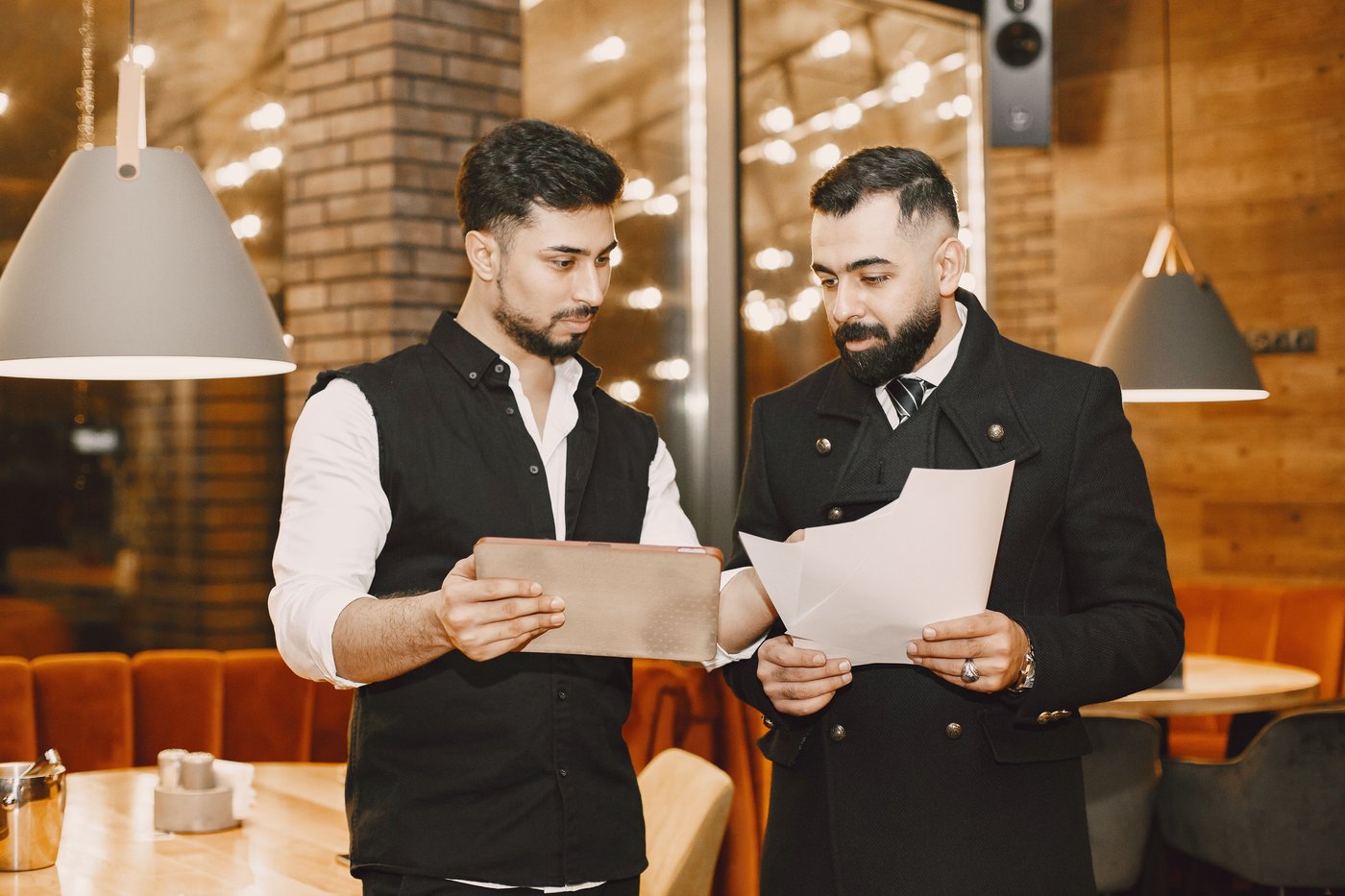 Two venue managers reviewing a brief together on the restaurant floor
