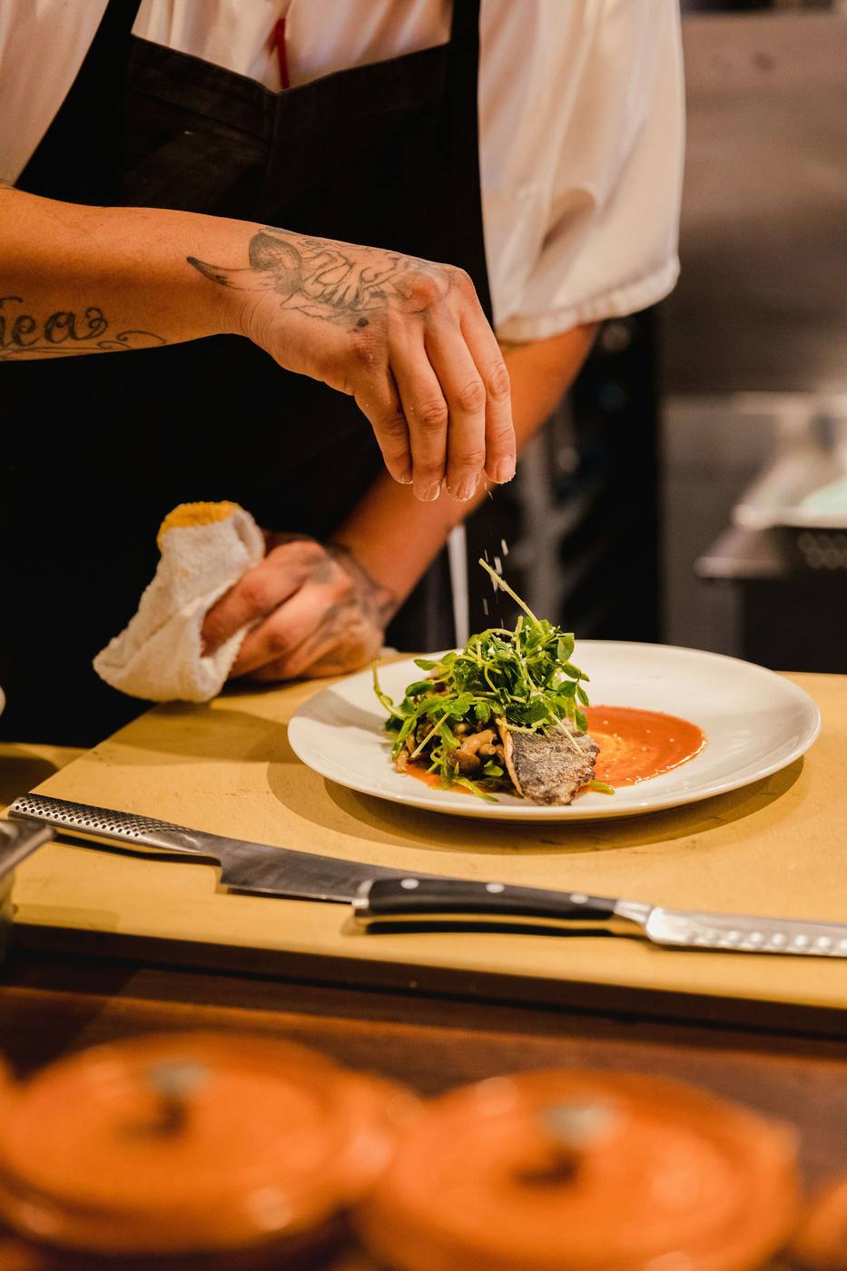 Chef placing the final garnish on a fine-dining plate