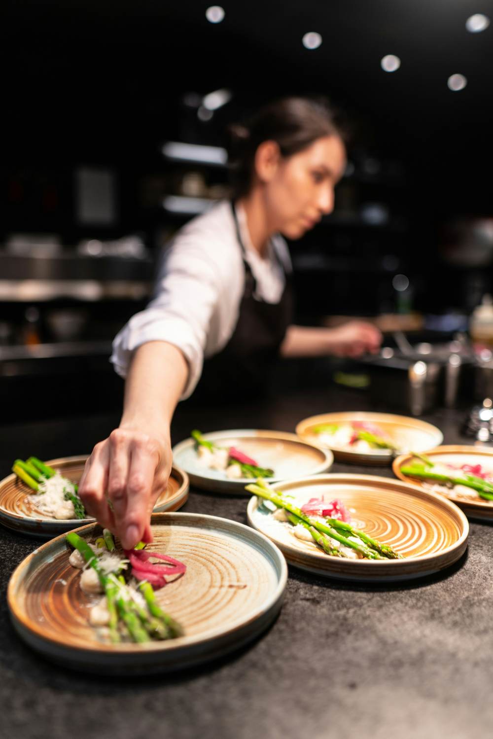 Chefs plating dishes along the pass