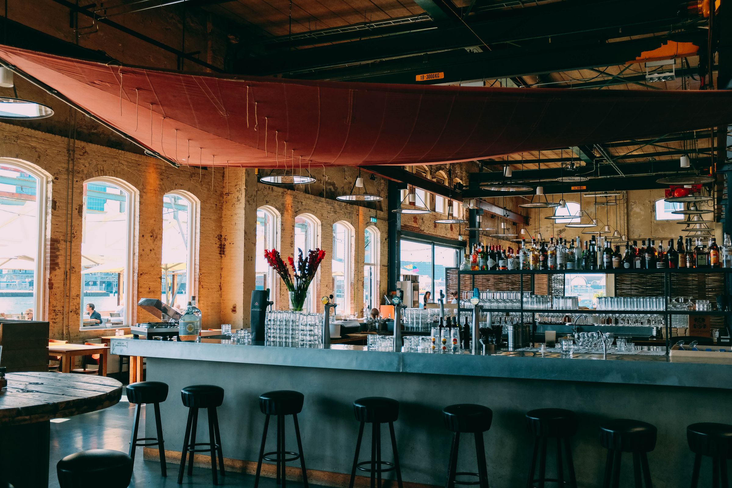 A large restaurant floor and bar in a converted warehouse