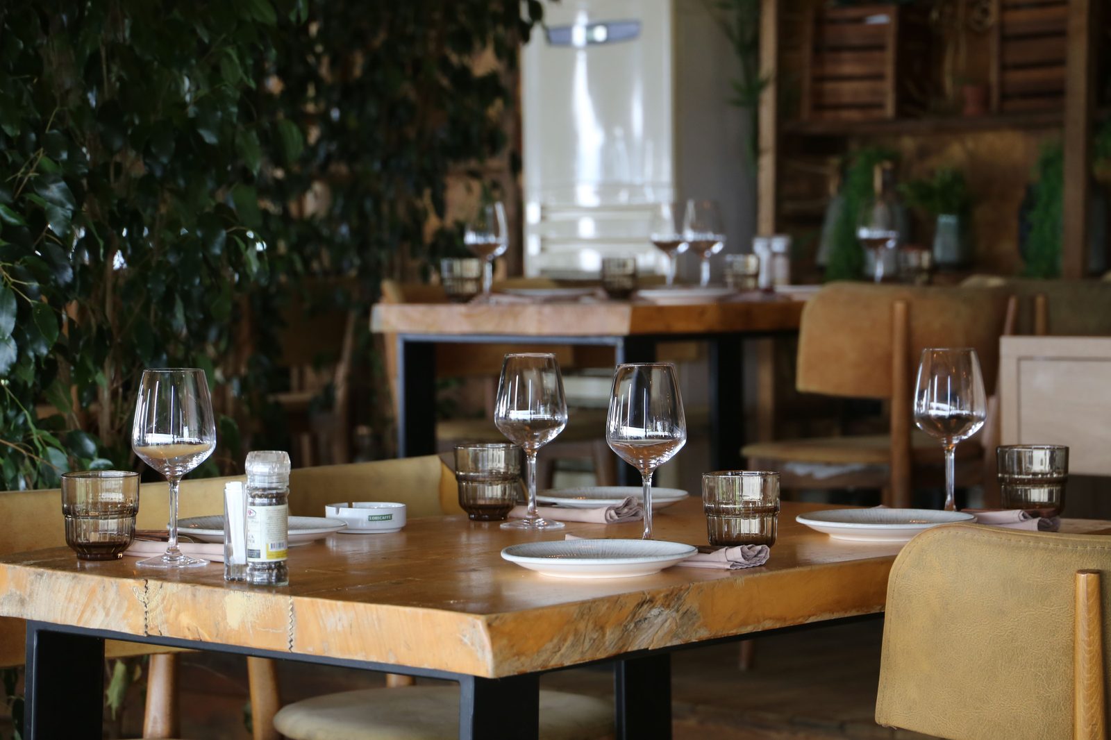 A restaurant dining room set for service in daylight