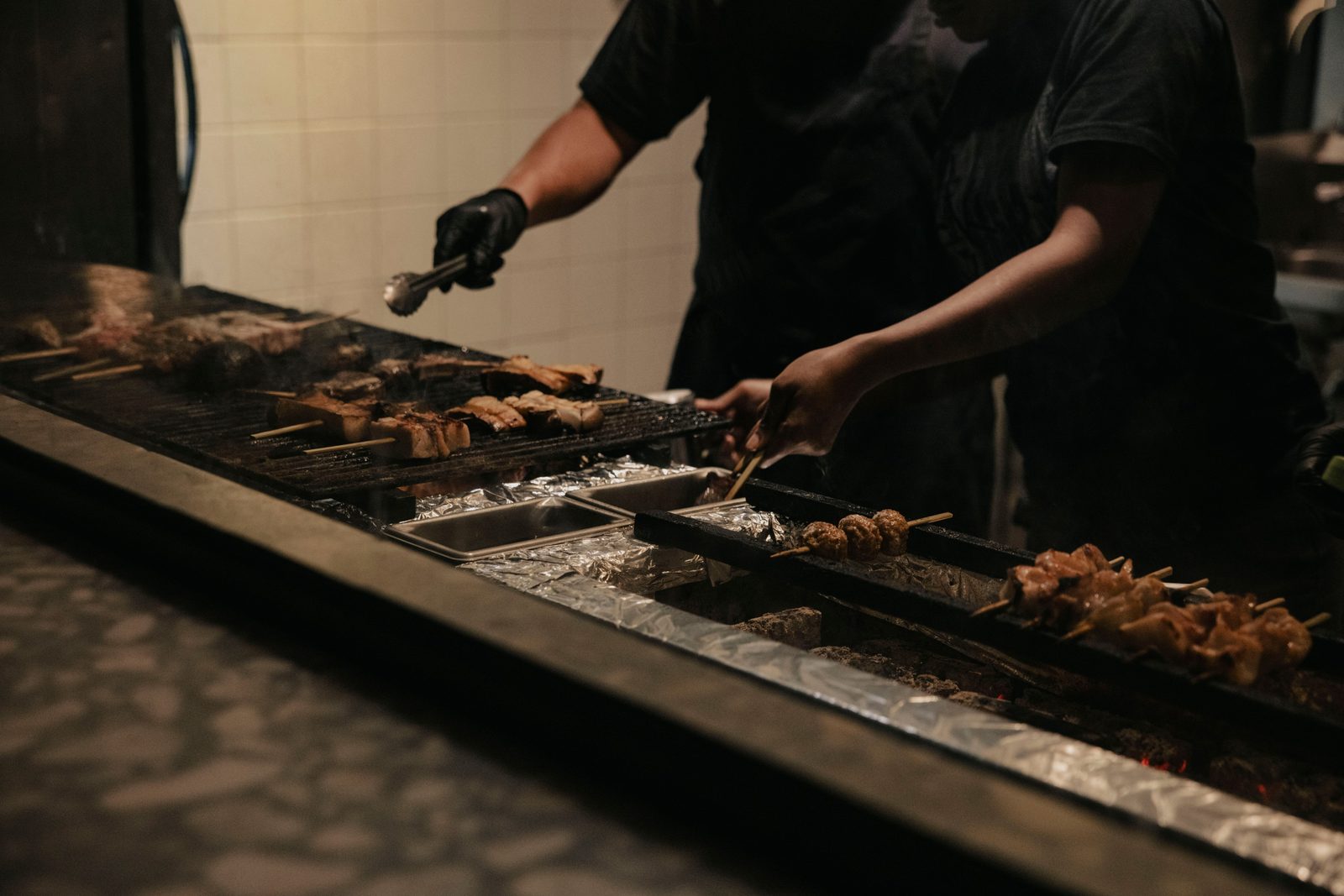Chef working a charcoal grill during service