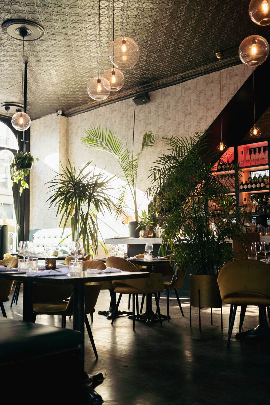 A bright restaurant floor with plants and open seating