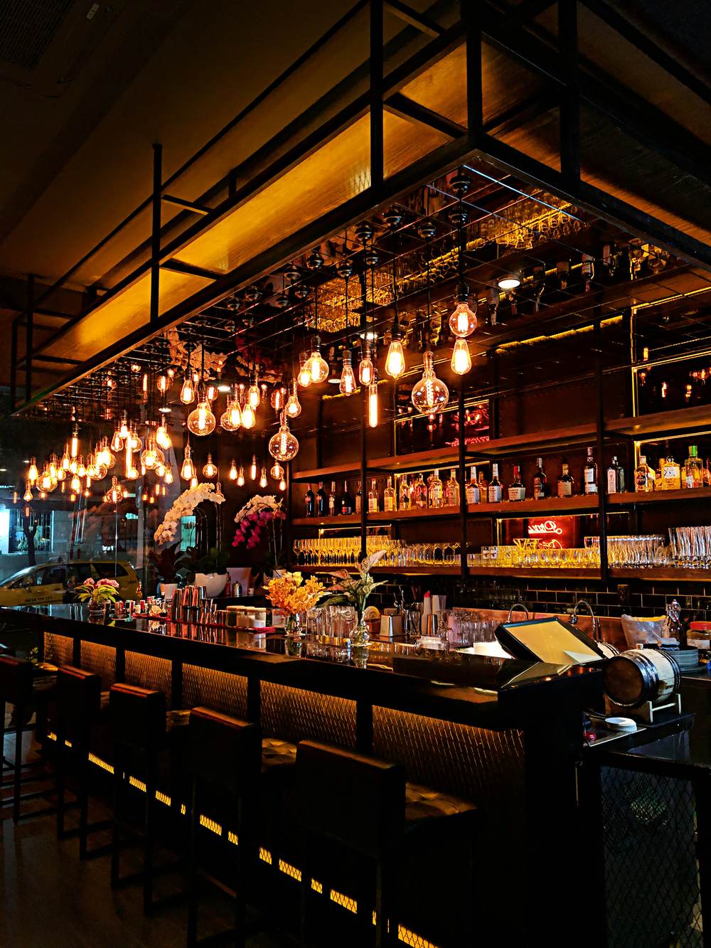 A busy bar lit by hanging pendant lights