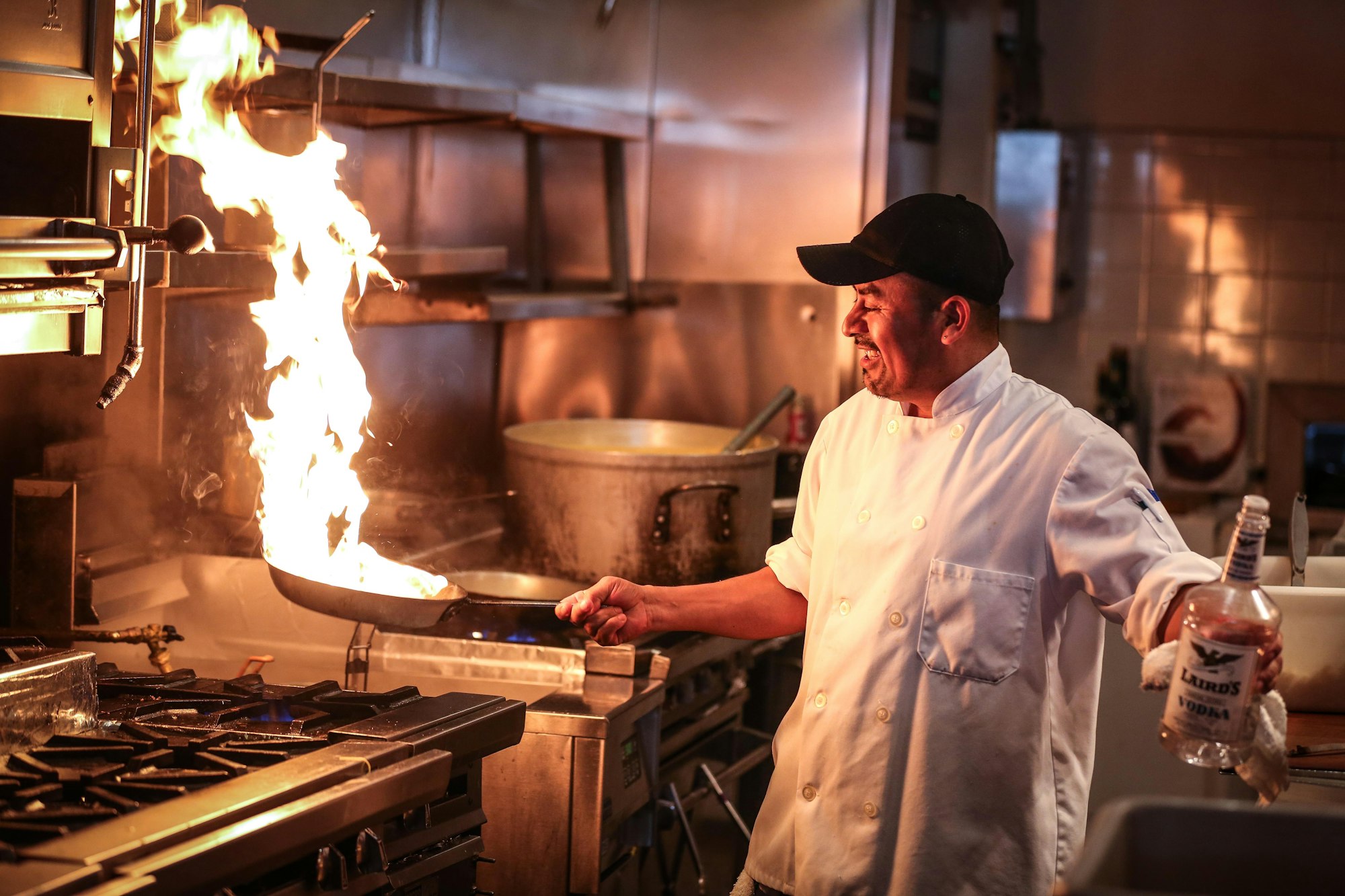 Chef flambéing a pan on the line during service